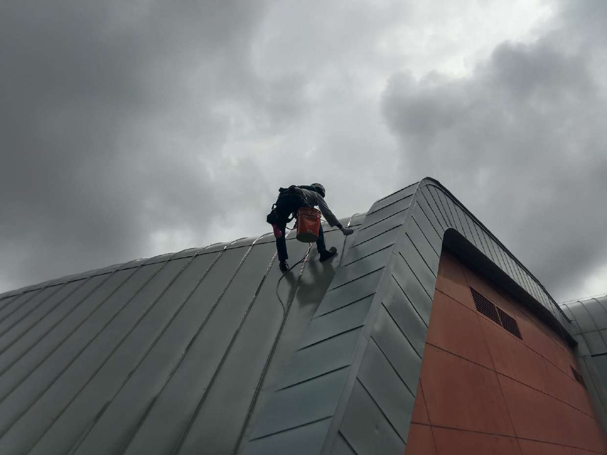 High-access waterproofing specialist working on a roof facade