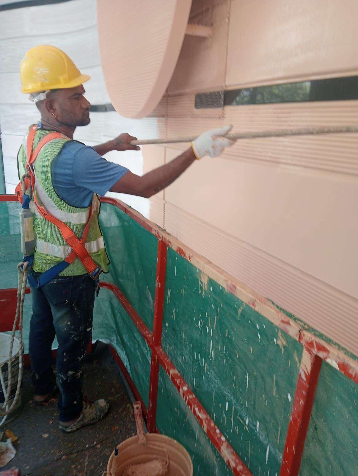 RR Engineering painter coating a building facade