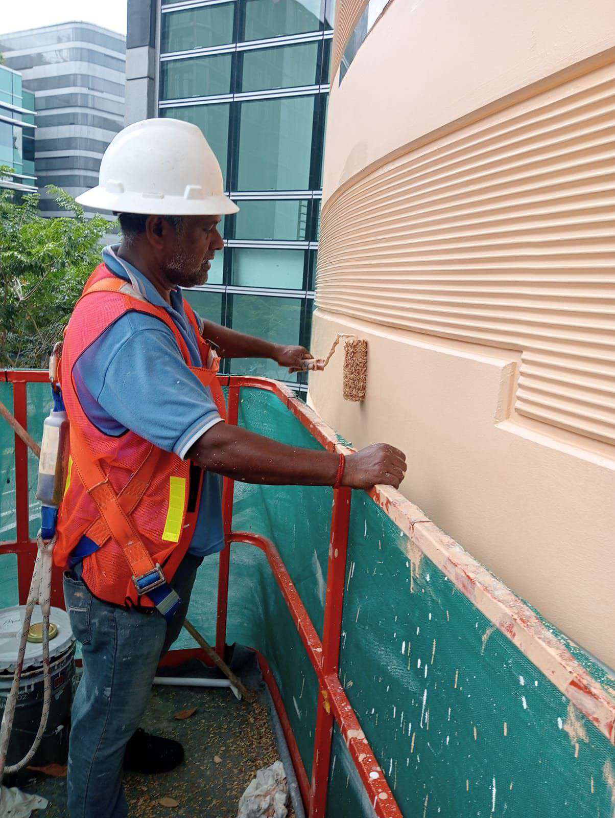 Painter applying an even finish to an exterior wall